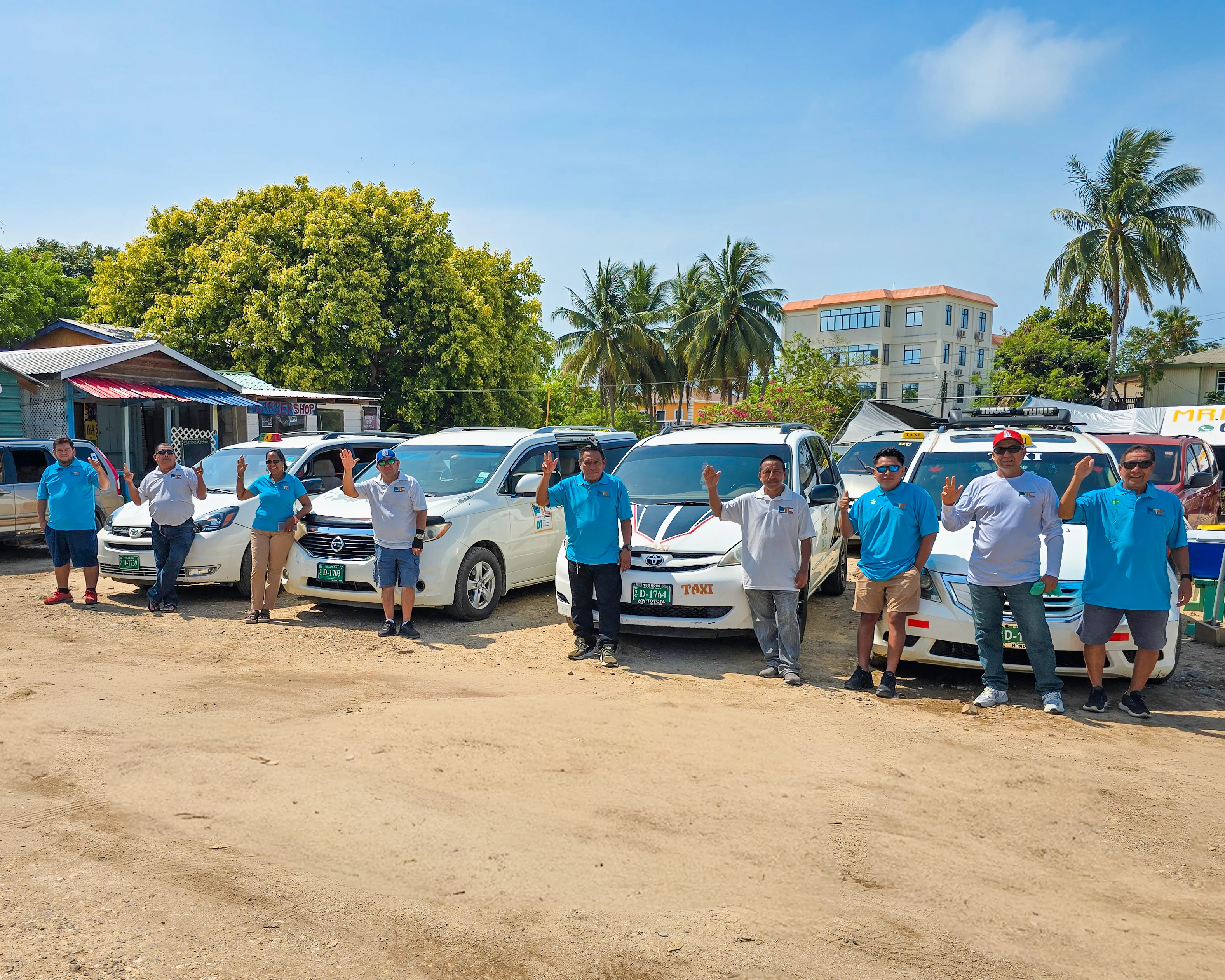 Placencia Taxi Cooperative members standing together in front of their taxis.